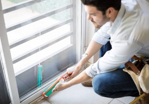 closeup-young-handyman-applying-some-sealant-door-with-sealing-gun-scaled.jpg
